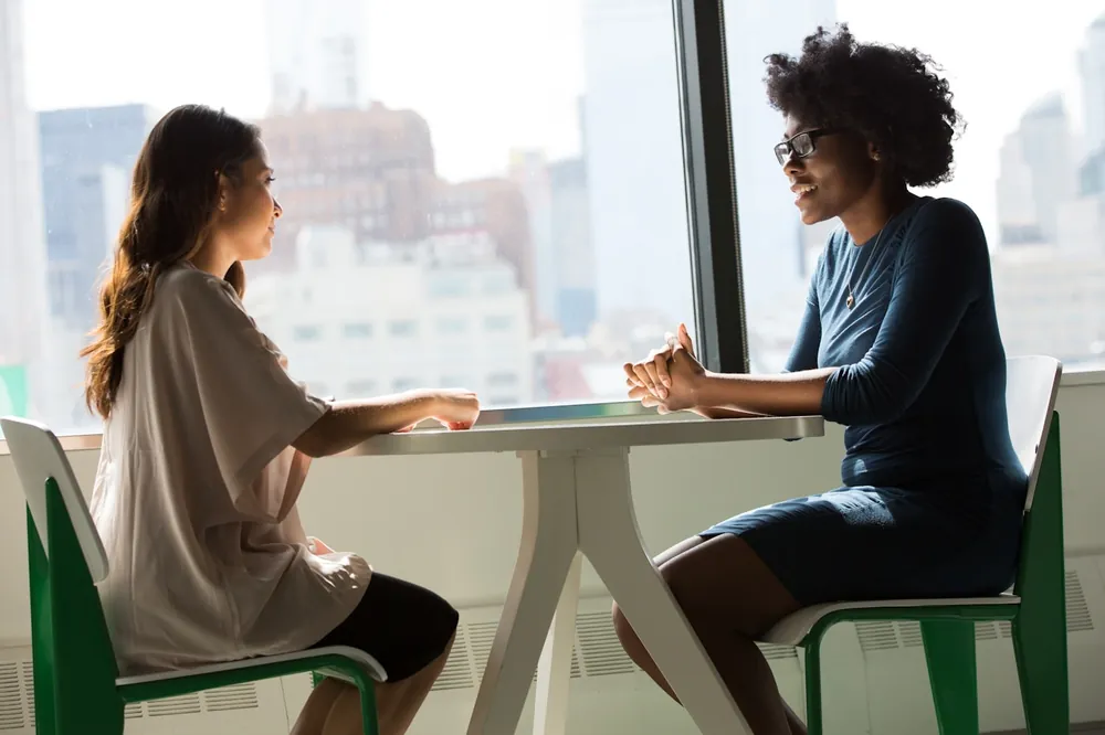 Illustrative photograph of two colleagues in conversation at a table, representing workplace and employment matters.